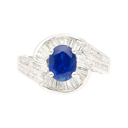 Natural 1.14 Carat Oval Cut Blue Sapphire with Round & Baguette Cut Diamonds in a Swirled 18K White Gold Ring Setting